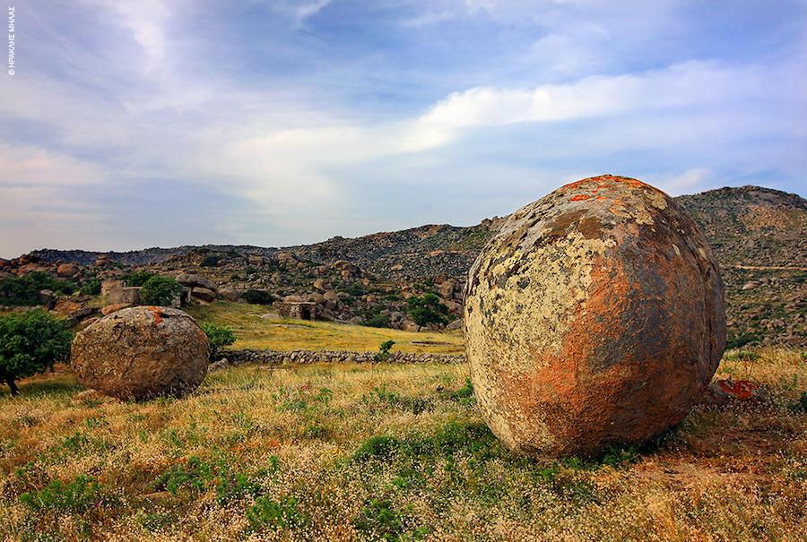Tinos, Volakas, Festival at Panagia Kalaman - Gastronomy Tours spherical rocks in nature on the dry grass at Tinos, Volakas
